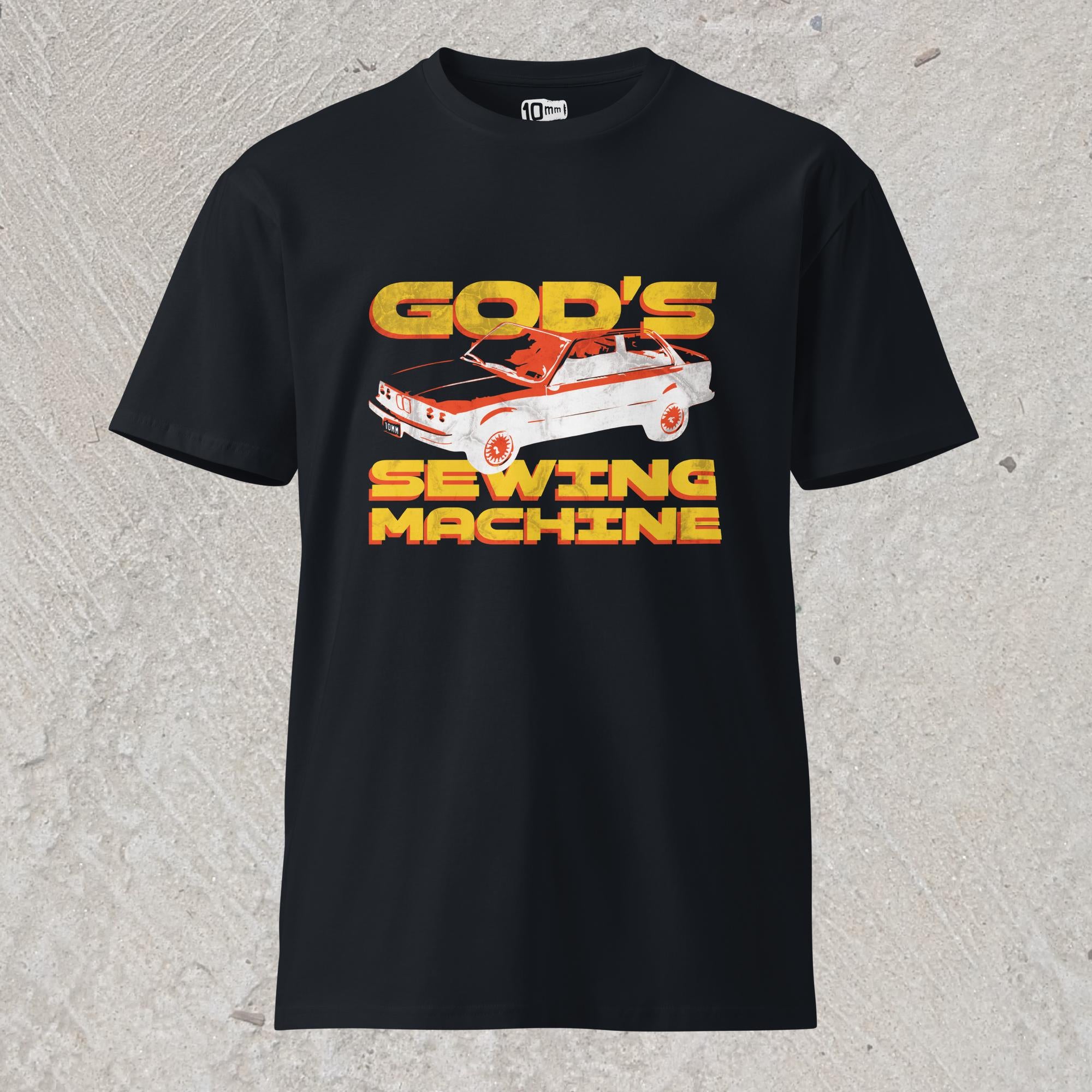 10mm funny car graphic navy T-shirt displaying BMW E30 with yellow text that reads “GOD’S SEWING MACHINE”