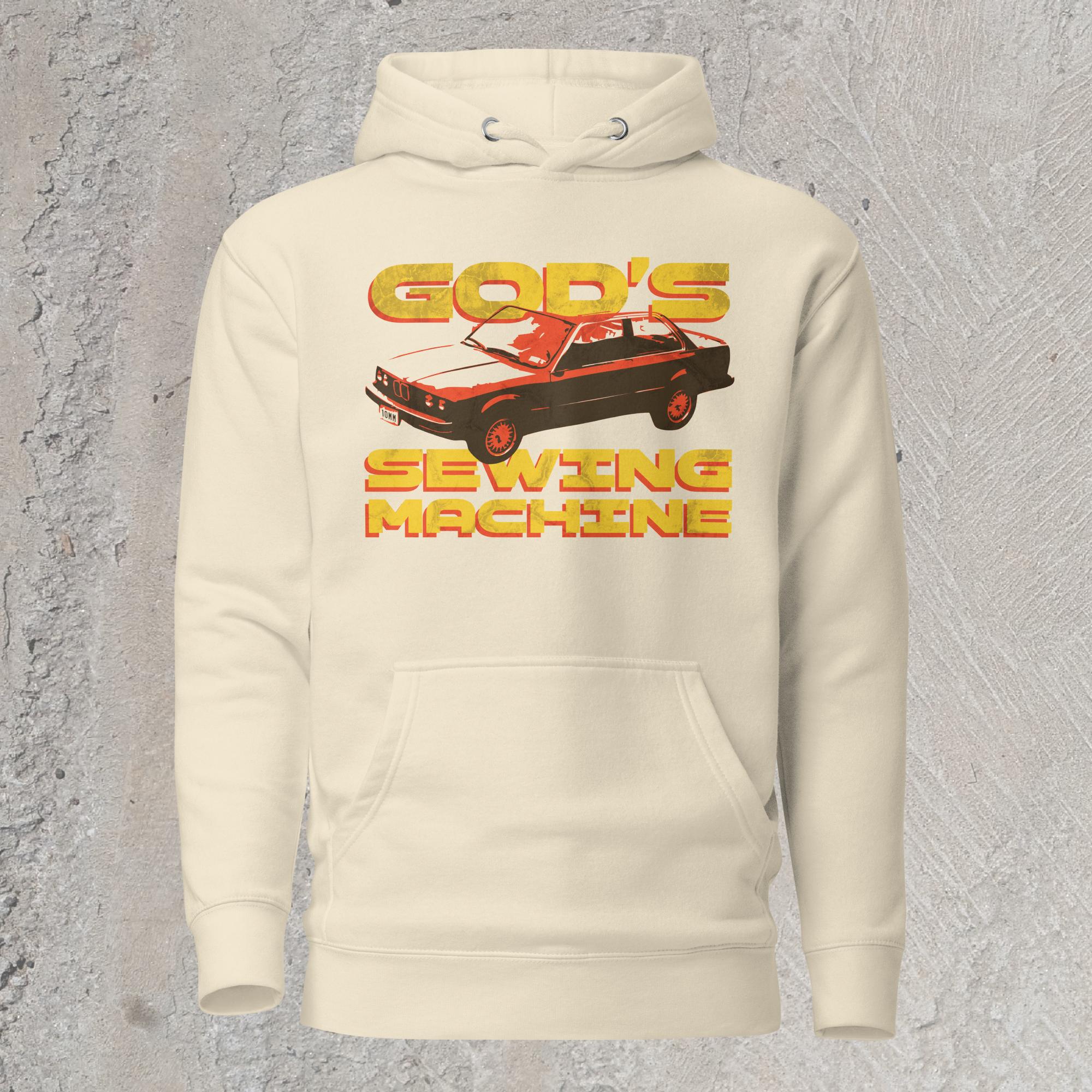 10mm funny car graphic cream colored white hoodie sweatshirt displaying BMW E30 with yellow text that reads “GOD’S SEWING MACHINE”