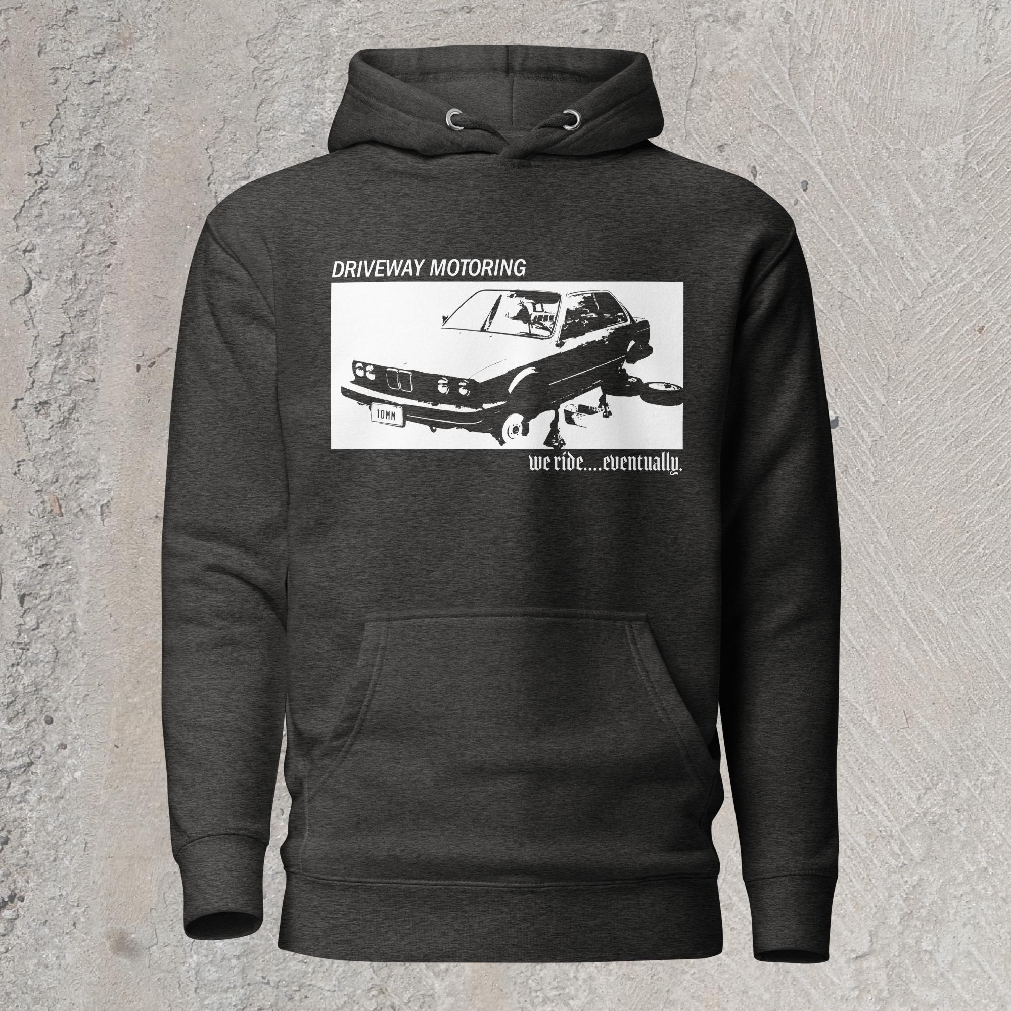 10mm funny graphic charcoal hoodie sweatshirt with BMW car on jack stands with text "Driveway motoring. We ride...eventually"