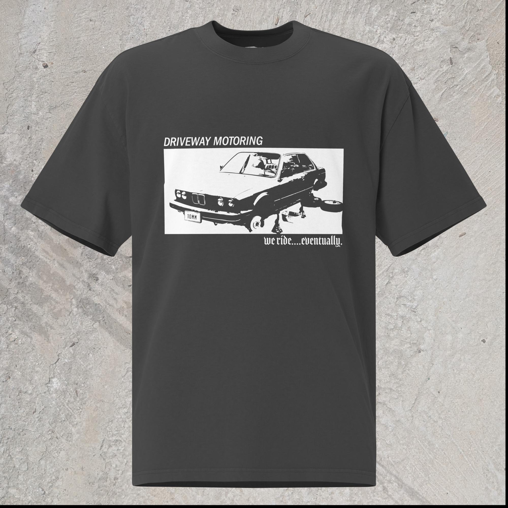 10mm funny graphic black oversized T-shirt with BMW car on jack stands with text "Driveway motoring. We ride...eventually