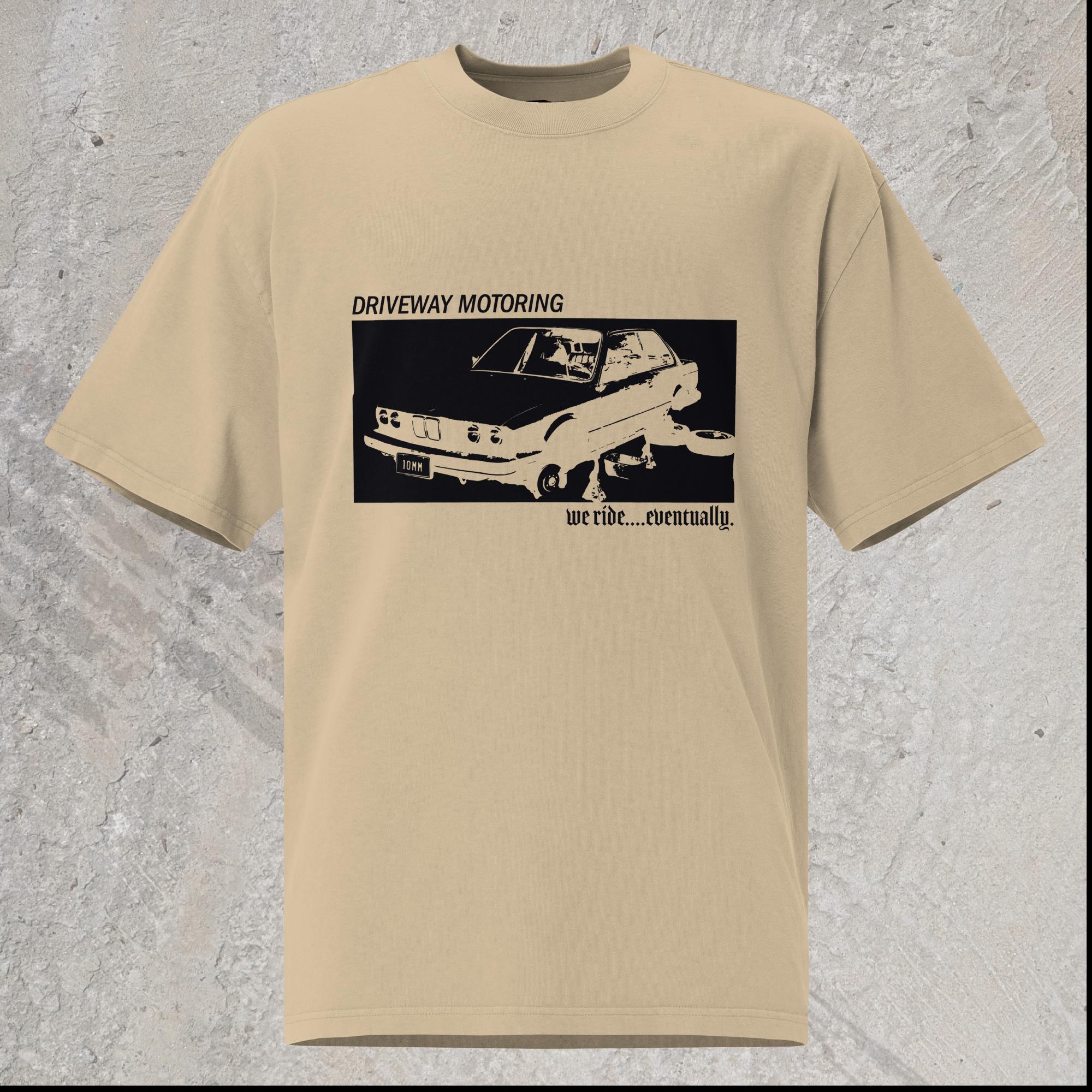 10mm funny graphic khaki oversized T-shirt with BMW car on jack stands with text "Driveway motoring. We ride...eventually"