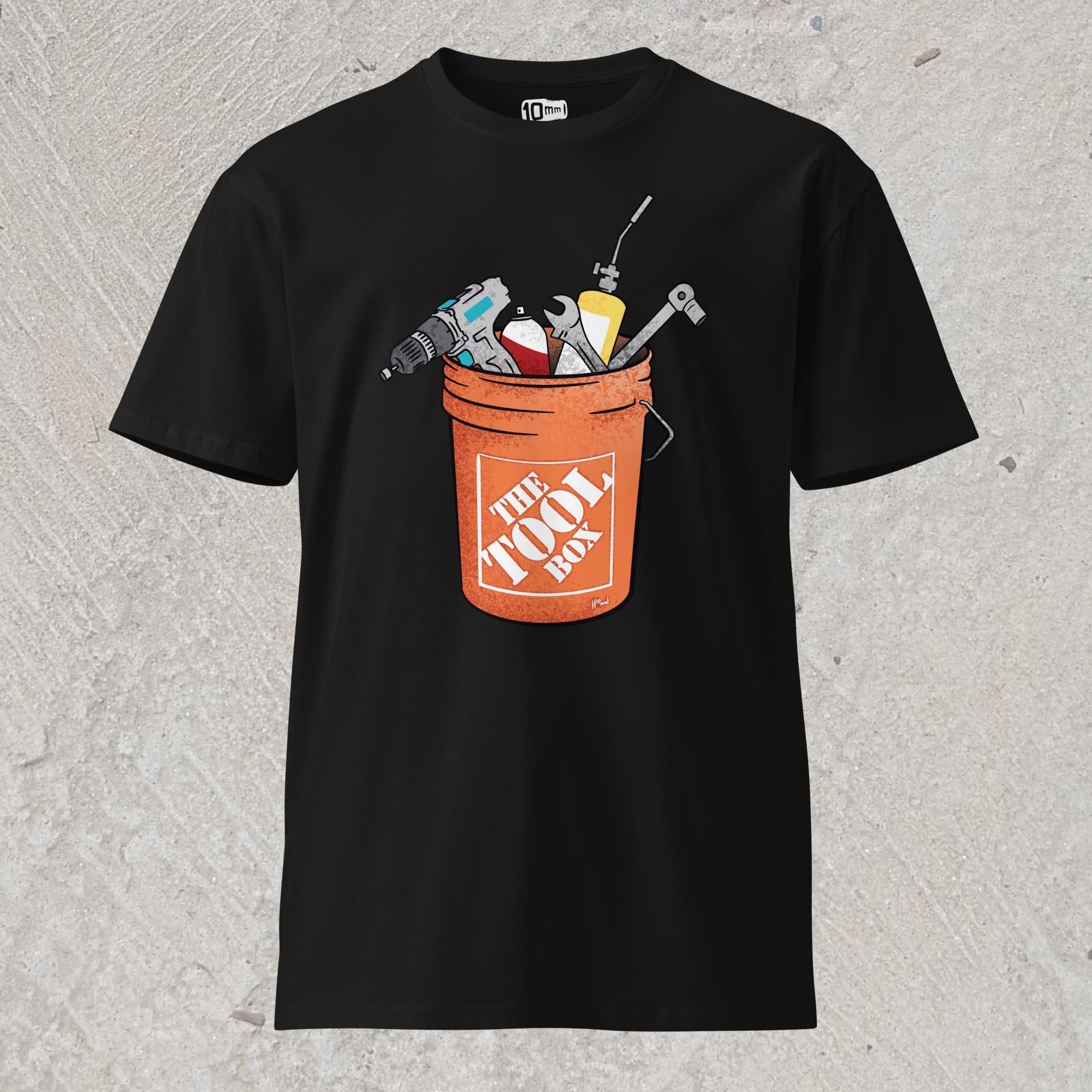 10mm funny graphic black T-shirt with orange bucket full of tools for working on cars. Text on bucket reads “The Tool Box”