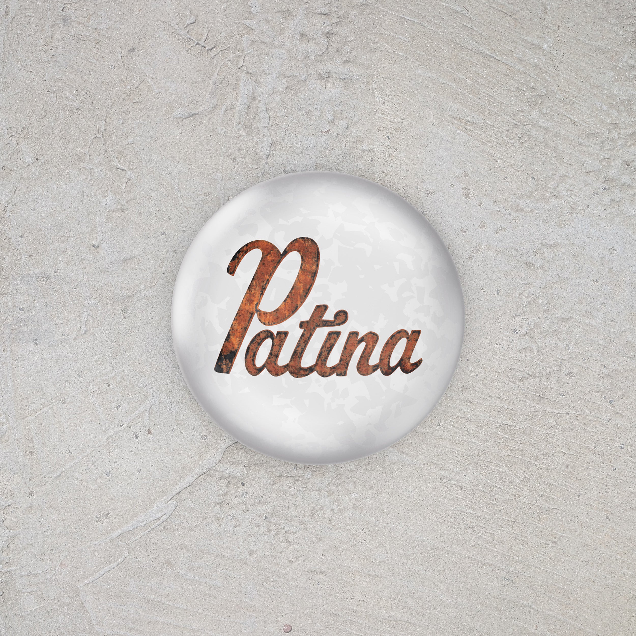 Button badge with 'Patina' text on a textured gray background